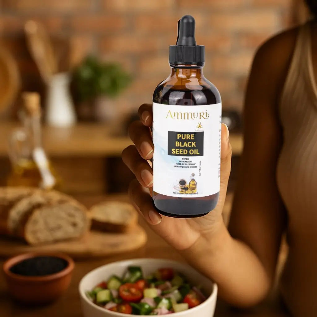 Ammuri Skincare pure black seed oil cold pressed in a bottle, held by a person in a kitchen with fresh ingredients