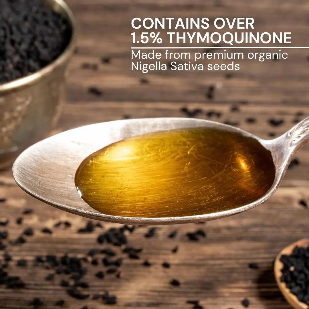 Pure black seed oil cold pressed in a spoon, showcasing rich color and high thymoquinone content from organic seeds