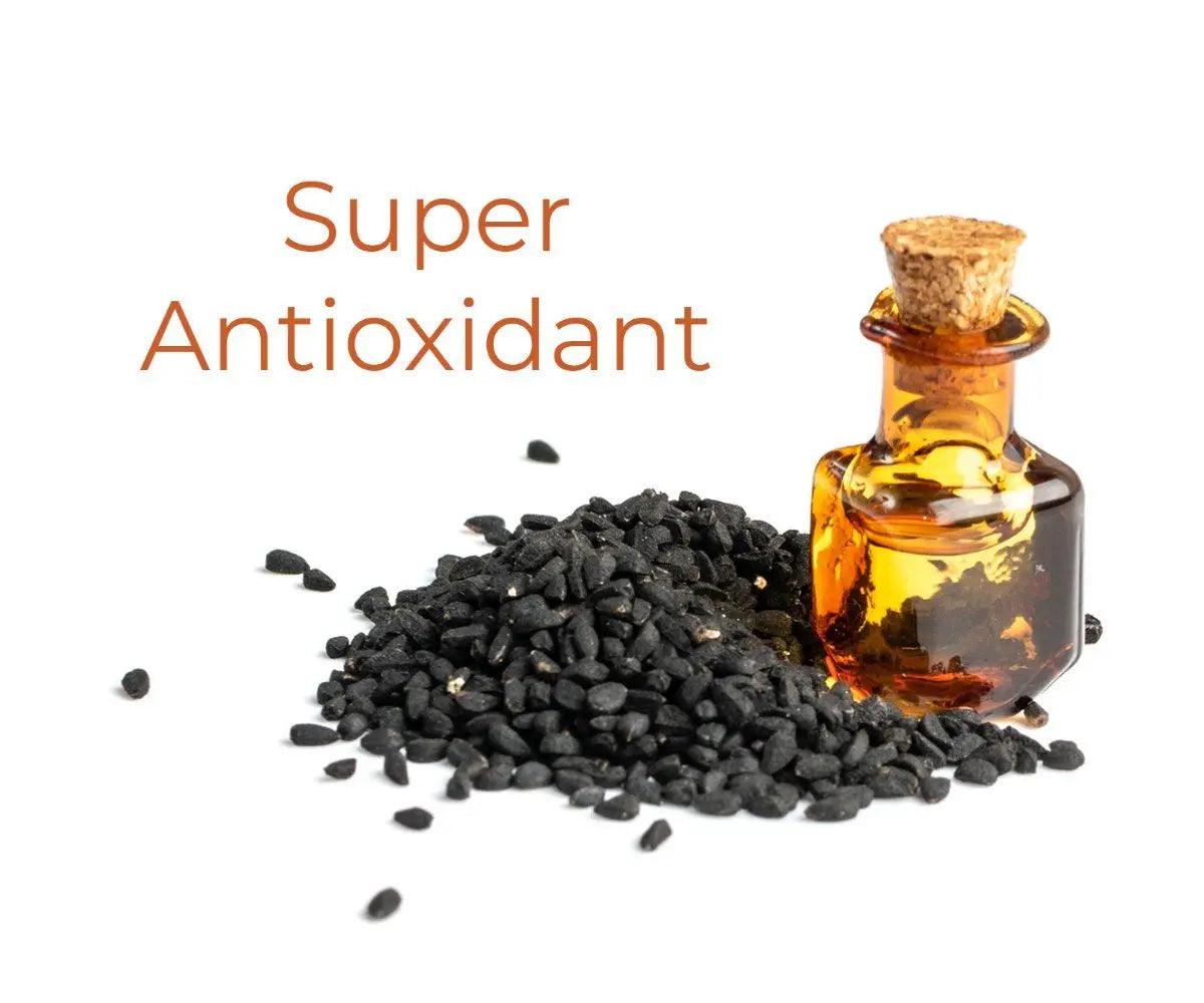 Ammuri Skincare pure black seed oil cold pressed in a small glass bottle with black seeds scattered around
